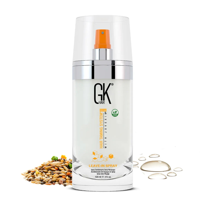 GK Hair Leave-In Hair Spray 120 ml clear pump bottle, orange nozzle and vegan badge, beside mixed seeds and oil droplets