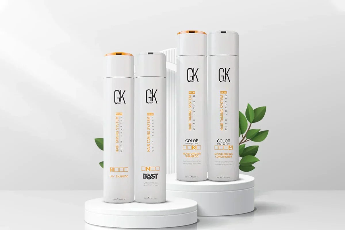 Four white GK Hair Keratin Treatment Kit are displayed on circular pedestals, surrounded by green leaves. The modern and clean design conveys a fresh, professional look.
