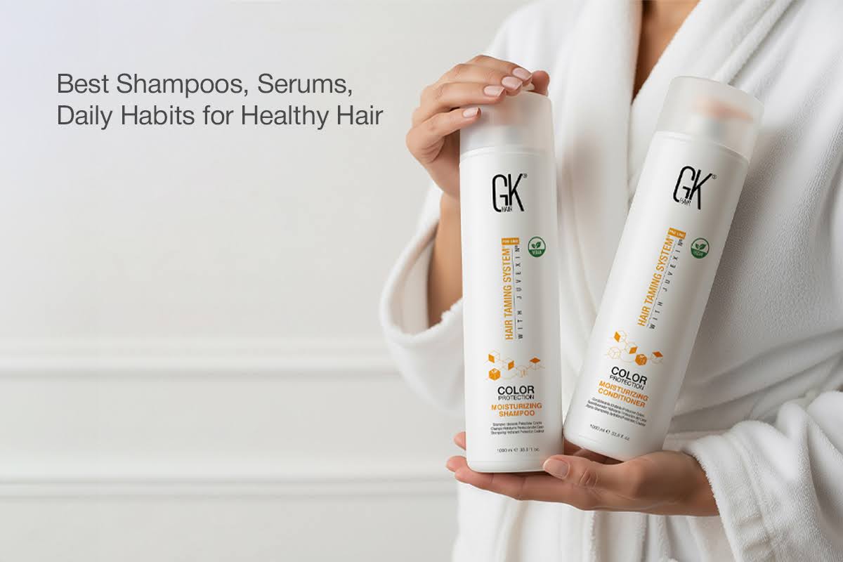 Person in a white robe holding GK Hair Moisturizing Shampoo and Conditioner. Text reads "Best Shampoos, Serums, Daily Habits for Healthy Hair." Clean, fresh tone.