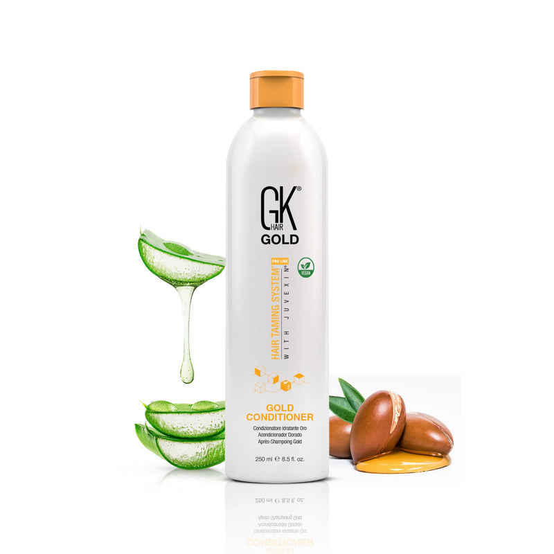 GK Hair Gold Conditioner 250 ml white bottle with an orange cap, flanked by dripping aloe vera slices and argan nuts with oil
