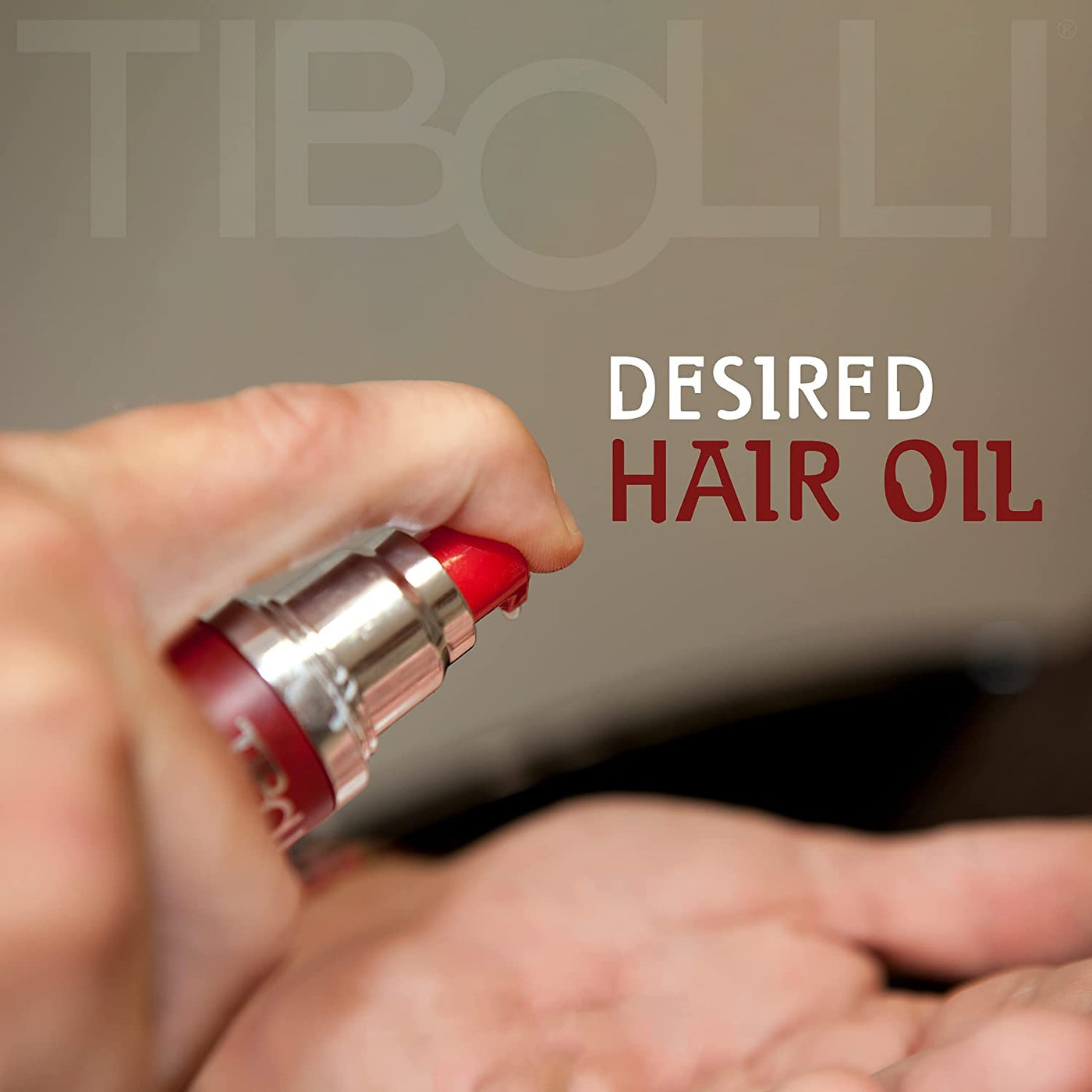 A close-up of a hand pressing the pump of a red Tibolli hair oil bottle, dispensing product onto the other palm, with the text “Desired Hair Oil” in the background.