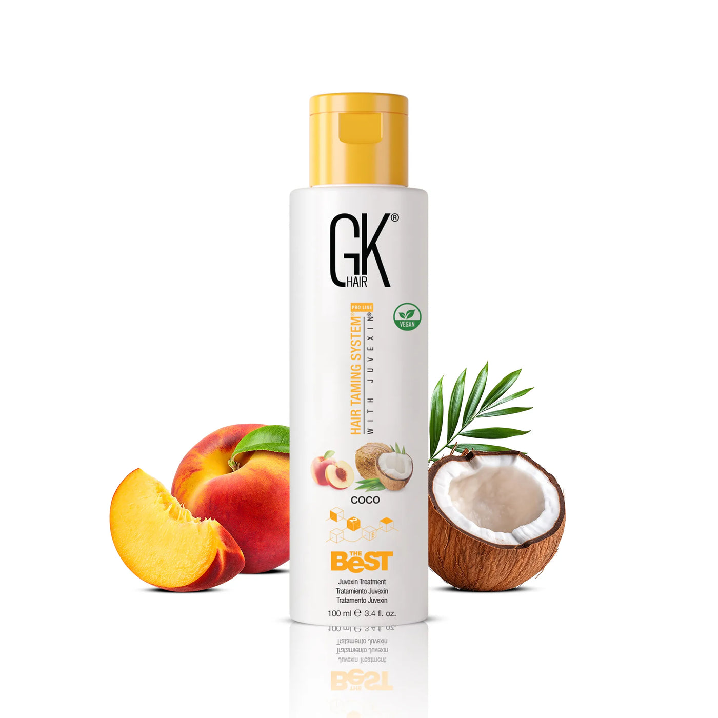 GK Hair's The Best Coco 100ml in-between a broken coconut and a whole apple alongside a sliced apple 